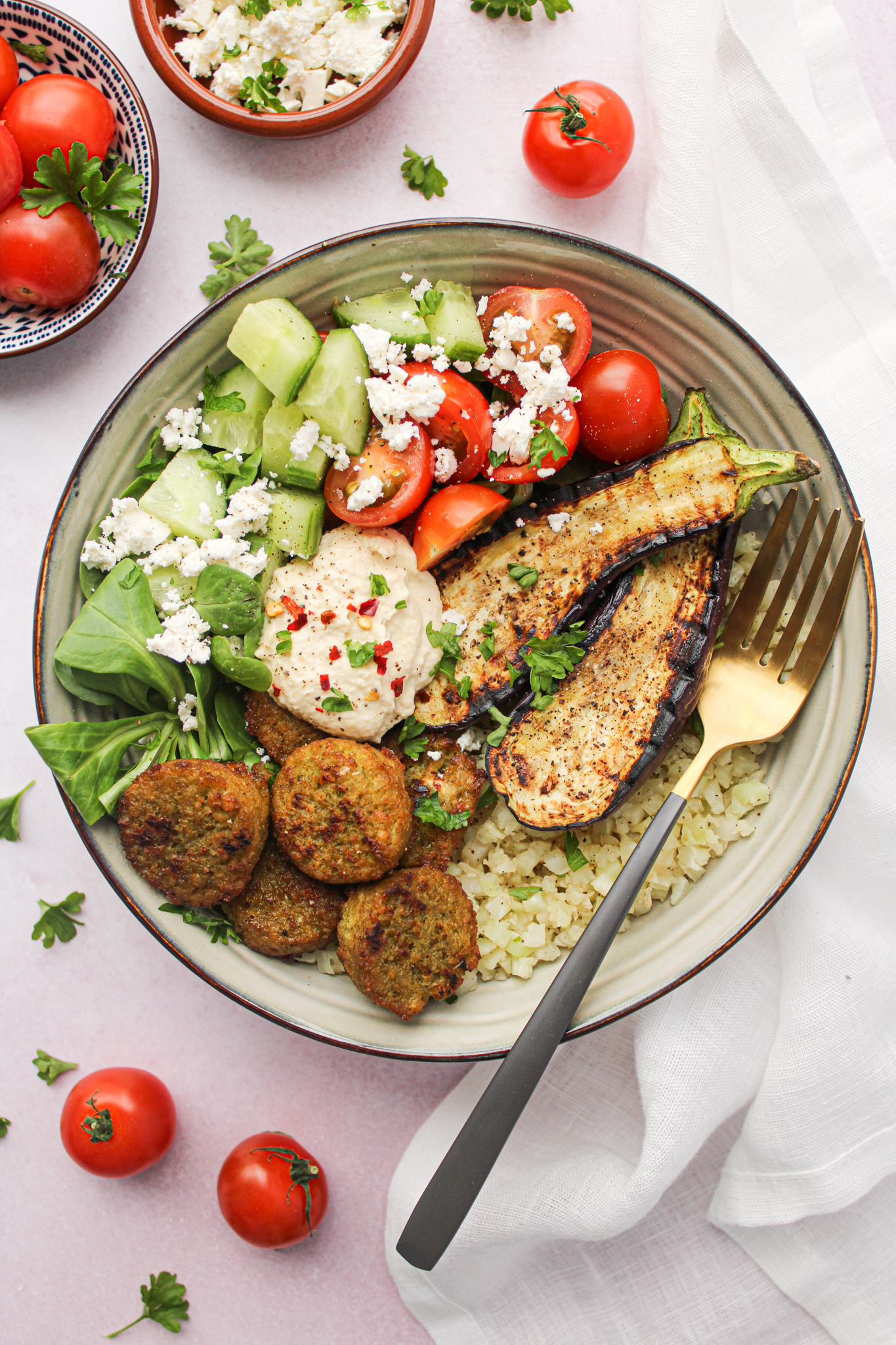 Gezonde Griekse salade met feta, tomaat, komkommer, falafel, bloemkoolrijst, aubergine en veldsla. Gezond, makkelijk, snel en lekker vegetarisch